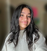 a girl in a white sweater smiles for the camera