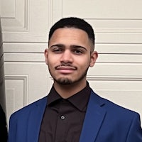 a young man in a blue suit standing in front of a garage door